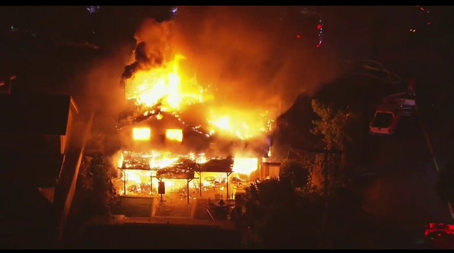 A home in San Bernardino County erupted into flames Monday during an hours-long SWAT standoff involving a suspect who died when police opened fire. (Credit: Fox 11)