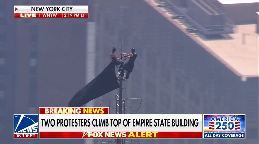 Manifestantes enmascarados trepan por la aguja del Empire State Building