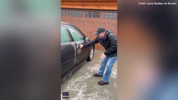 Watch as a man slips and slides trying to get into his car 