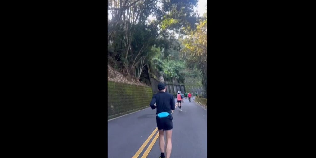 Marathon runner balances pineapple on his head