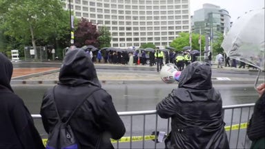 Dozens of protesters hold 'no war on Iran' signs outside White House Correspondents' Dinner