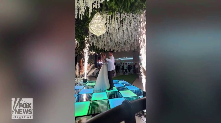 Wedding drama! Watch as a newly married couple keeps dancing when a fire breaks out behind them
