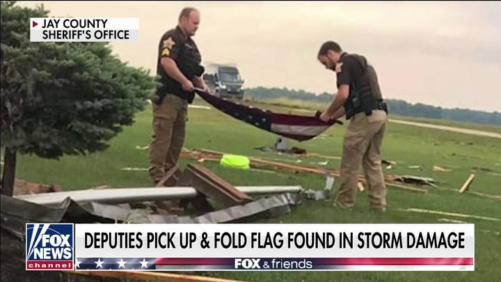 Indiana officers pick up, fold American flag found in tornado debris 