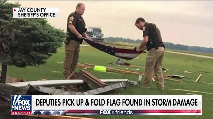 Indiana officers pick up, fold American flag found in tornado debris 