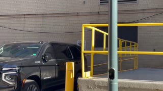 FBI agents load boxes into a car after searching John Bolton's DC office