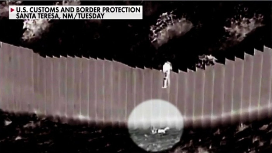 Shocking video shows smugglers drop young girls over border barrier