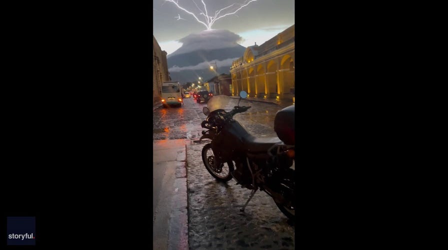 Thunderstorm produces stunning lightning bolts above volcano