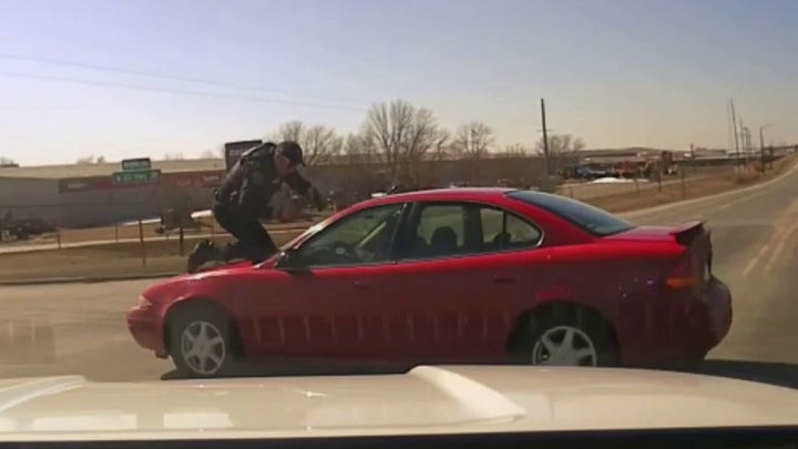 Iowa police officer clings to roof of suspect’s car during chase