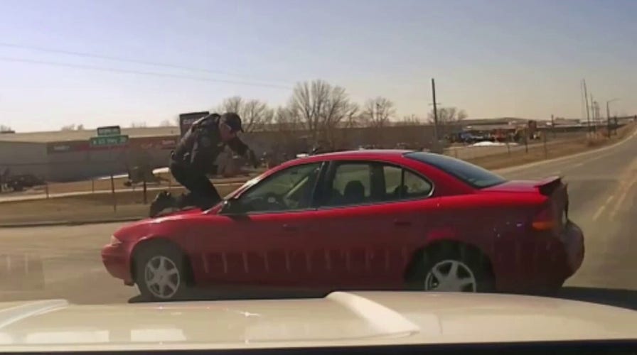 Iowa police officer clings to roof of suspect’s car during chase