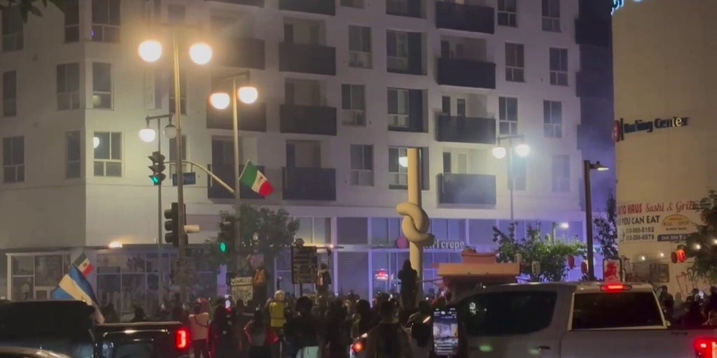 Protestors flee downtown Los Angeles street corner after police deploy tear gas