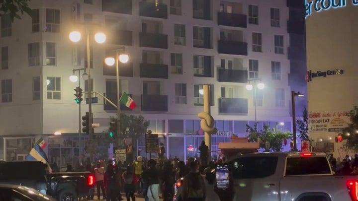 Protesters flee downtown Los Angeles street corner after police deploy tear gas