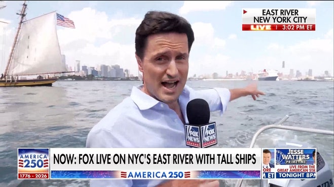 Tall ships sail past Statue of Liberty in New York Harbor