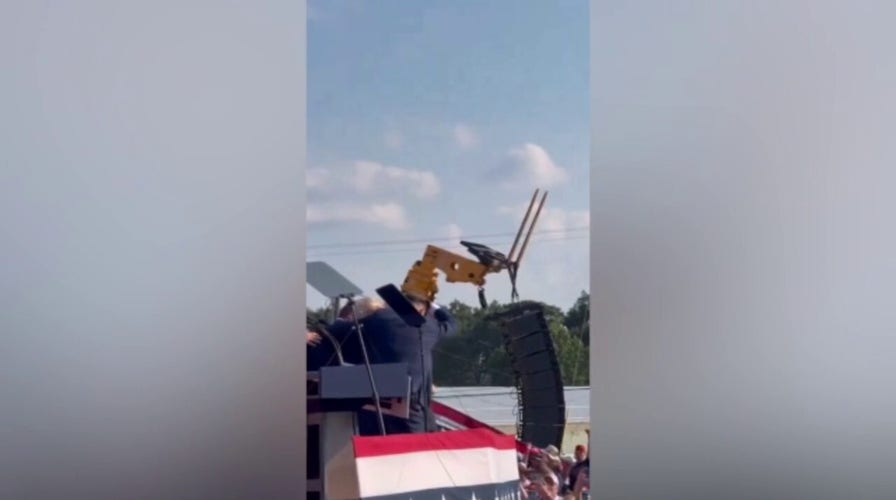 Former President Trump gives a thumbs up to the crowd while evacuating rally incident