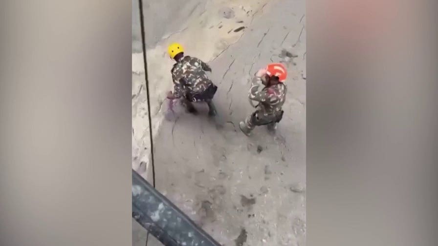 Rescue workers drag trapped Nepalis from a hydropower tunnel after fatal mudslides