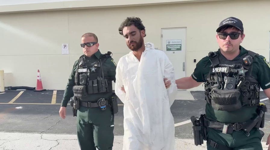 Raul Lionel Vazquez escorted by sheriff deputies after allegedly shooting a man running away from him