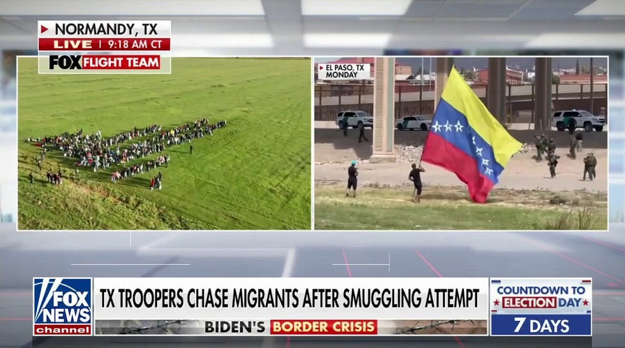 Massive group of Venezuelan migrants cross border, wave flag on US soil