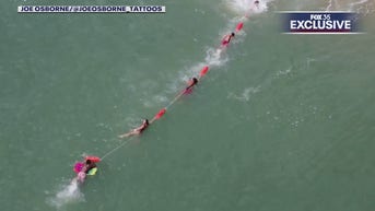 Florida lifeguards form human chain to rescue boogie boarder, drone video shows