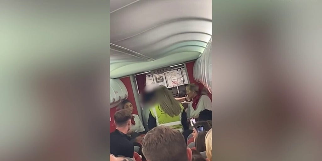 Officers escort two passengers off flight at UK airport