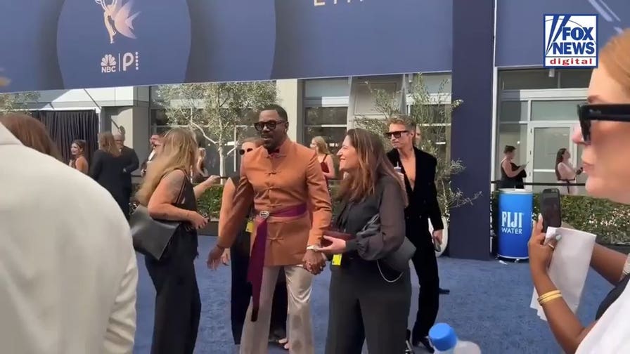 Colman Domingo chats with attendees while walking the 2026 Emmys red carpet