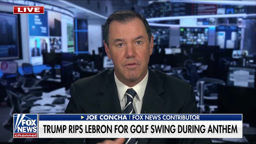 LeBron James practices his golf swing during national anthem