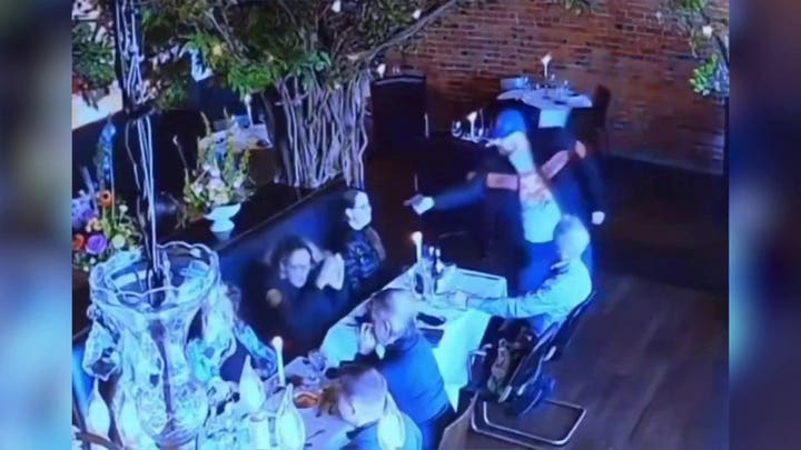 Un exabogado presuntamente apunta con un arma a su exmujer en un impactante vídeo de las cámaras de seguridad de un restaurante