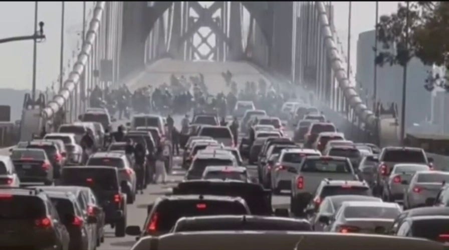 Video shows motorcyclists performing in a chaotic sideshow, stopping traffic on the Bay Bridge