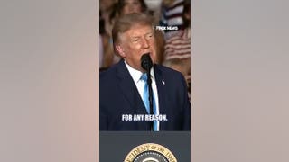 Trump signs executive order onstage during Nebraska rally