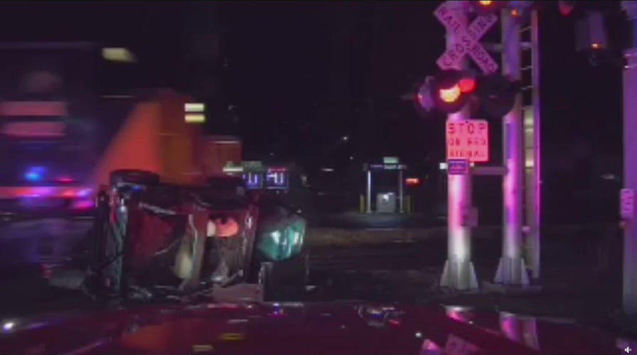 Michigan firefighters rescue driver inside overturned car from path of oncoming train