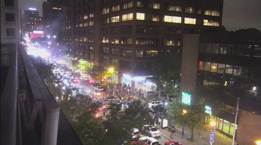 Cars doing donuts on Philadelphia street as fireworks go off