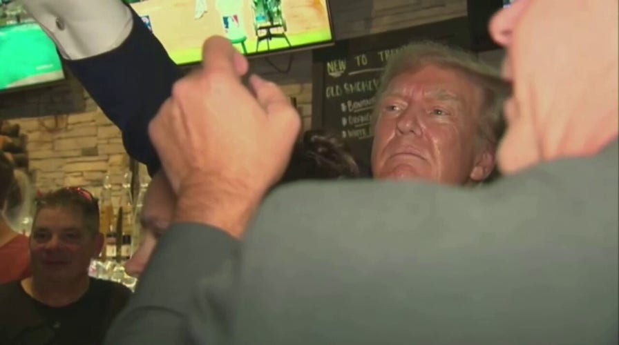 Former President Trump hands out pizza at Iowa pub