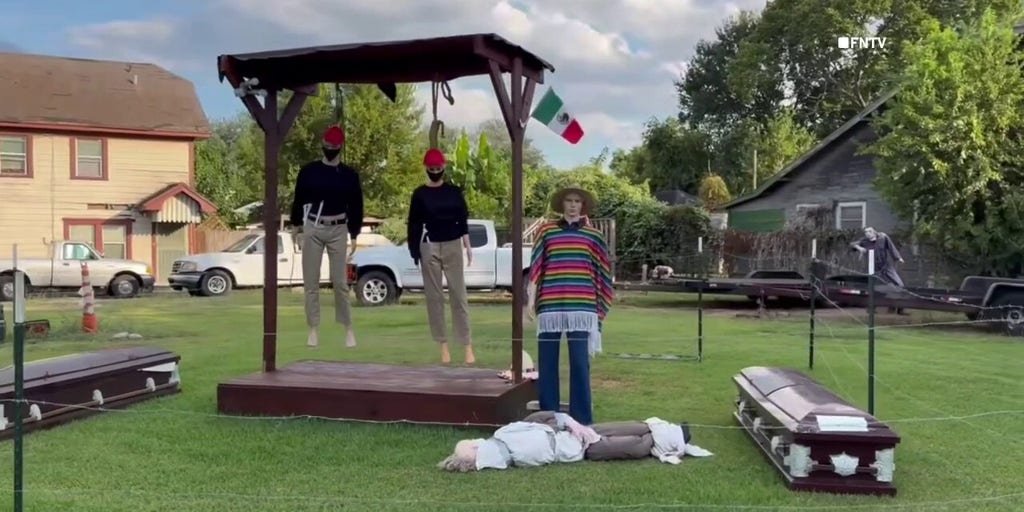 Mannequins dressed in red hats hang from gallows in Houston Halloween display