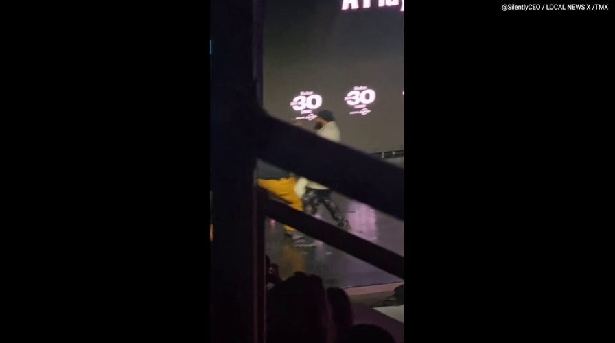 Machine Gun Kelly protected by security after fan storms stage