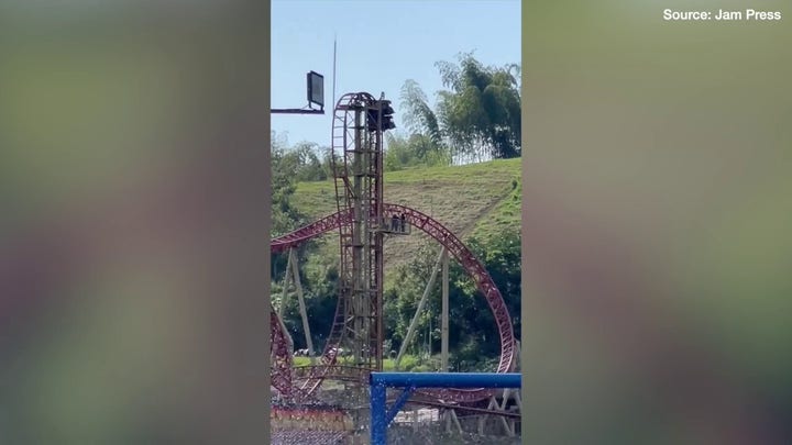 Terrifying moment amusement park riders get stuck 100ft in air as ride breaks down