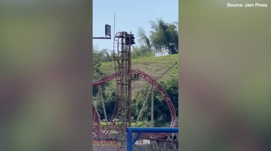 Terrifying moment amusement park riders get stuck 100ft in air as ride breaks down