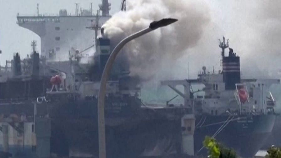 Smoke billows from cargo ship that caught fire while docked at Chinese port