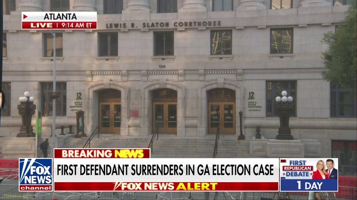 First defendant surrenders in Georgia election case