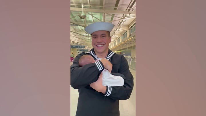 Navy wife surprises husband with newborn girl during airport reunion: 'It was magic in his eyes'