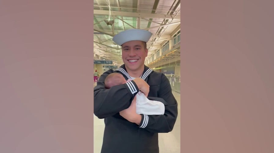 Navy wife surprises husband with newborn girl during airport reunion: 'It was magic in his eyes'