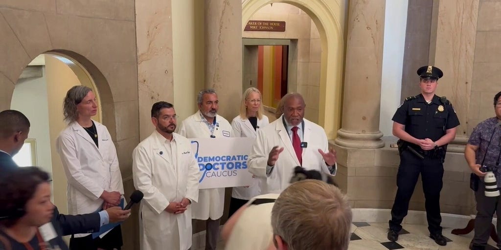 Tourists pass by Democratic Doctors Caucus press conference