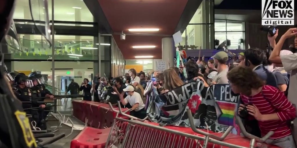Police hold agitators back with barricades outside Berkeley TPUSA event