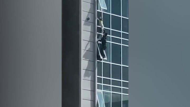 Heroic man saves boy hanging from a window in China