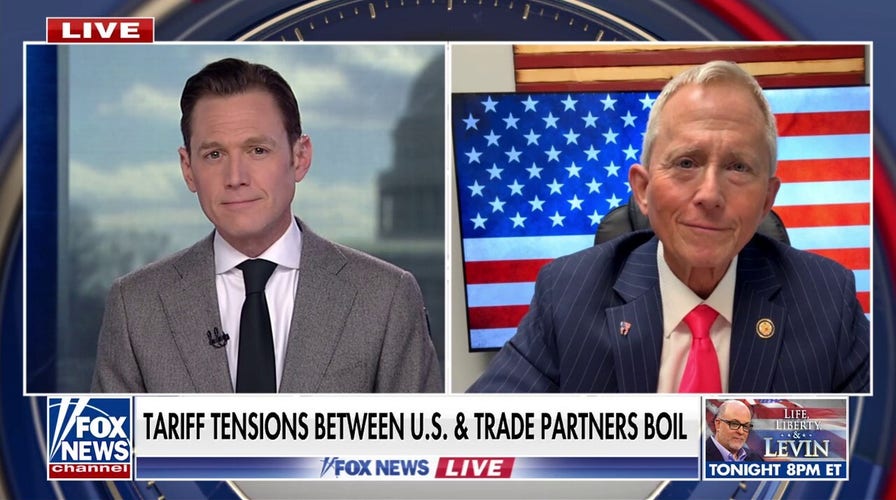two men in suits and ties are on a news program