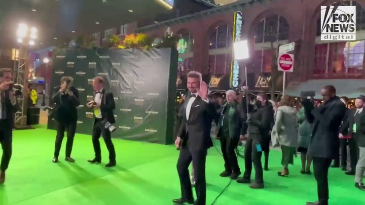 David Beckham waves to fans while walking the green carpet at the Earthshot Prize Awards