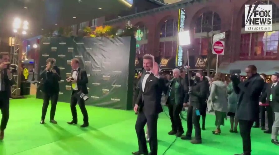 David Beckham waves to fans while walking the green carpet at the Earthshot Prize Awards