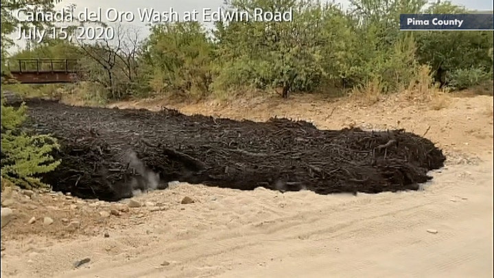 Flash flood carries charred debris from Bighorn Fire down a channel near Tucson