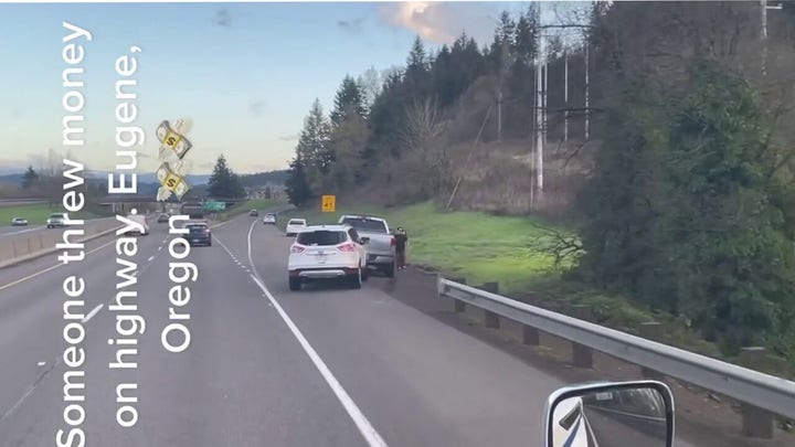Drivers in Oregon stop to pick up one-hundred-dollar bills on Interstate