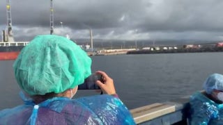 Cruise ship passengers wearing PPE disembark from ship at center of hantavirus outbreak