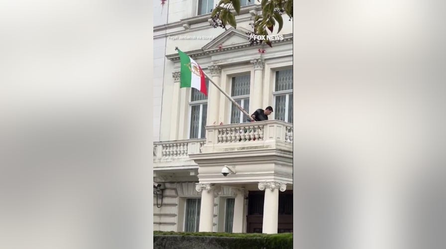 WATCH: Protester installs pre-revolution flag at Iranian embassy in London