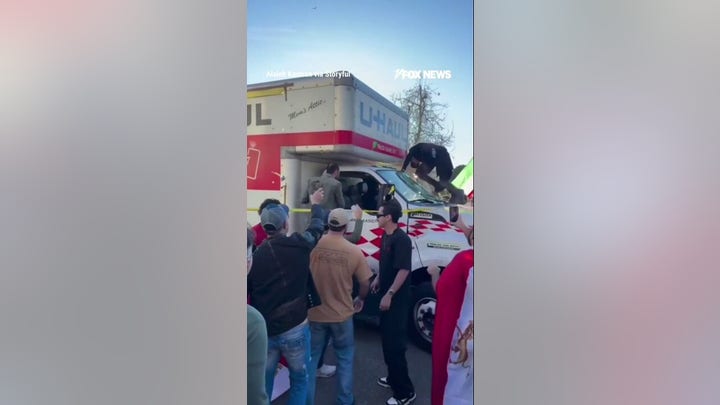 Demonstrators swarm U-Haul after it drove through Iran protest