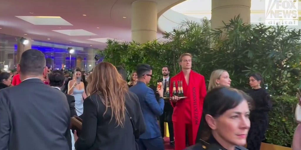 Demi Moore walks the red carpet in a gold dress at the 2025 Golden Globes